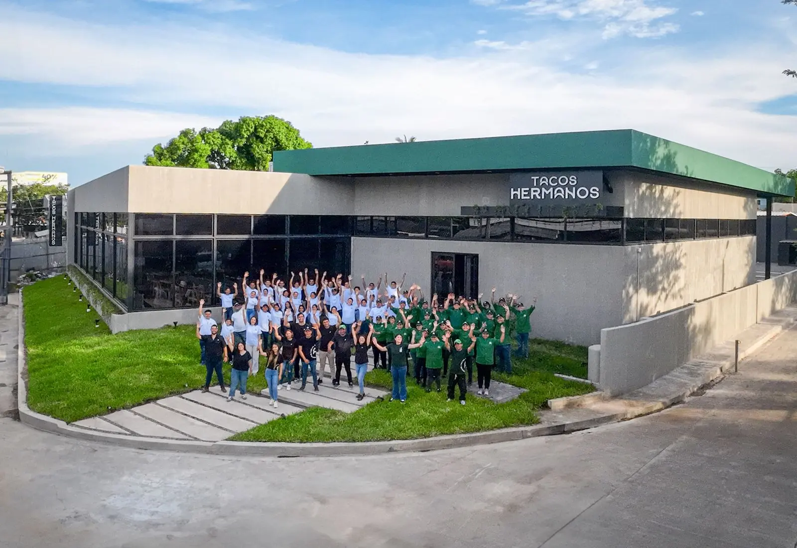 Todo el equipo de Tacos Hermanos frente a una de sus casas