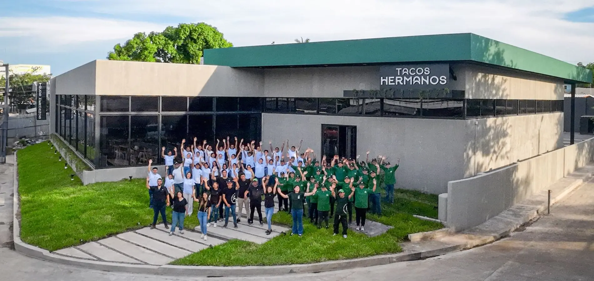 El equipo completo de Tacos Hermanos frente a una de sus casas